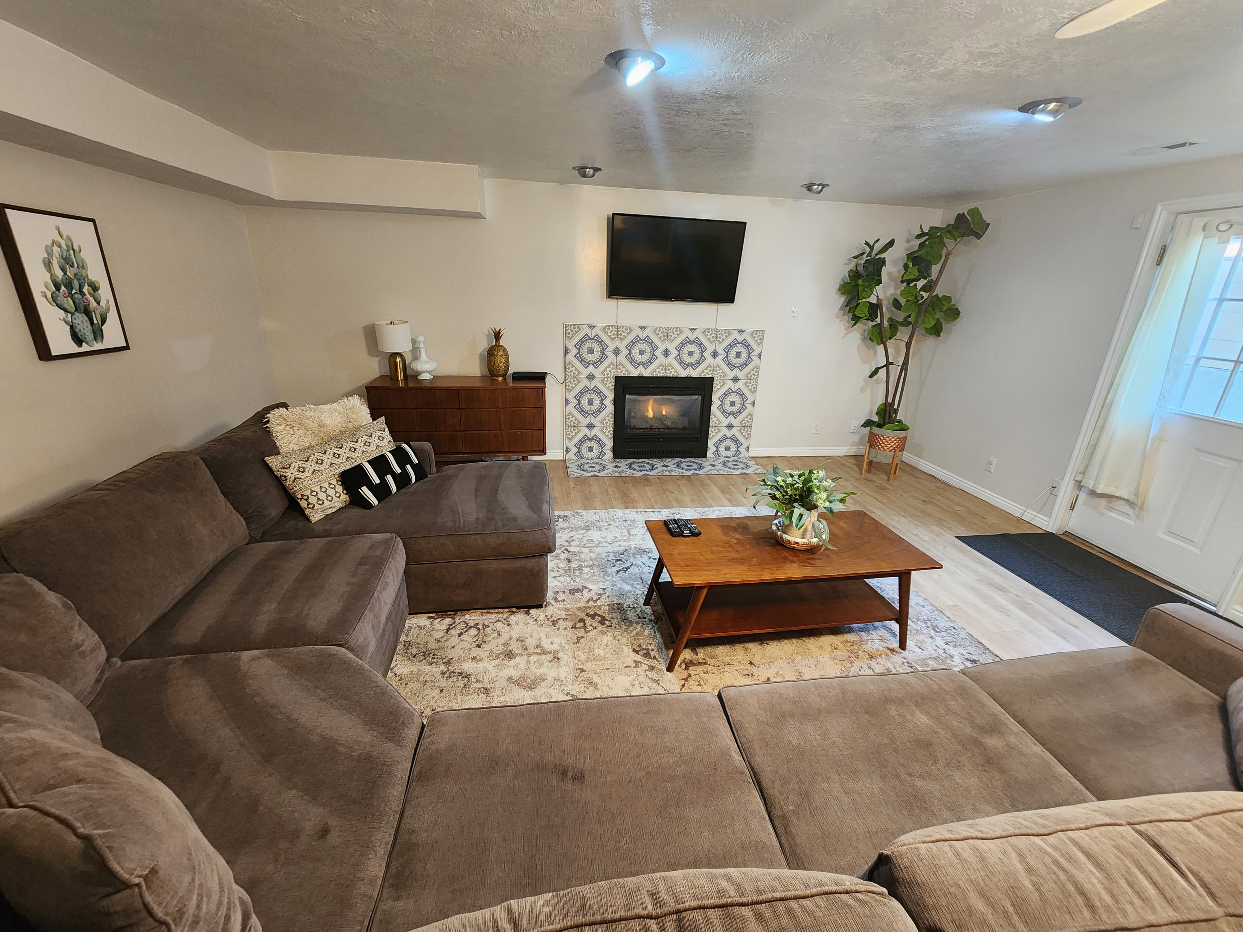 Living area featuring light wood-finish flooring, recessed lighting, and a fireplace with decorative tile surround