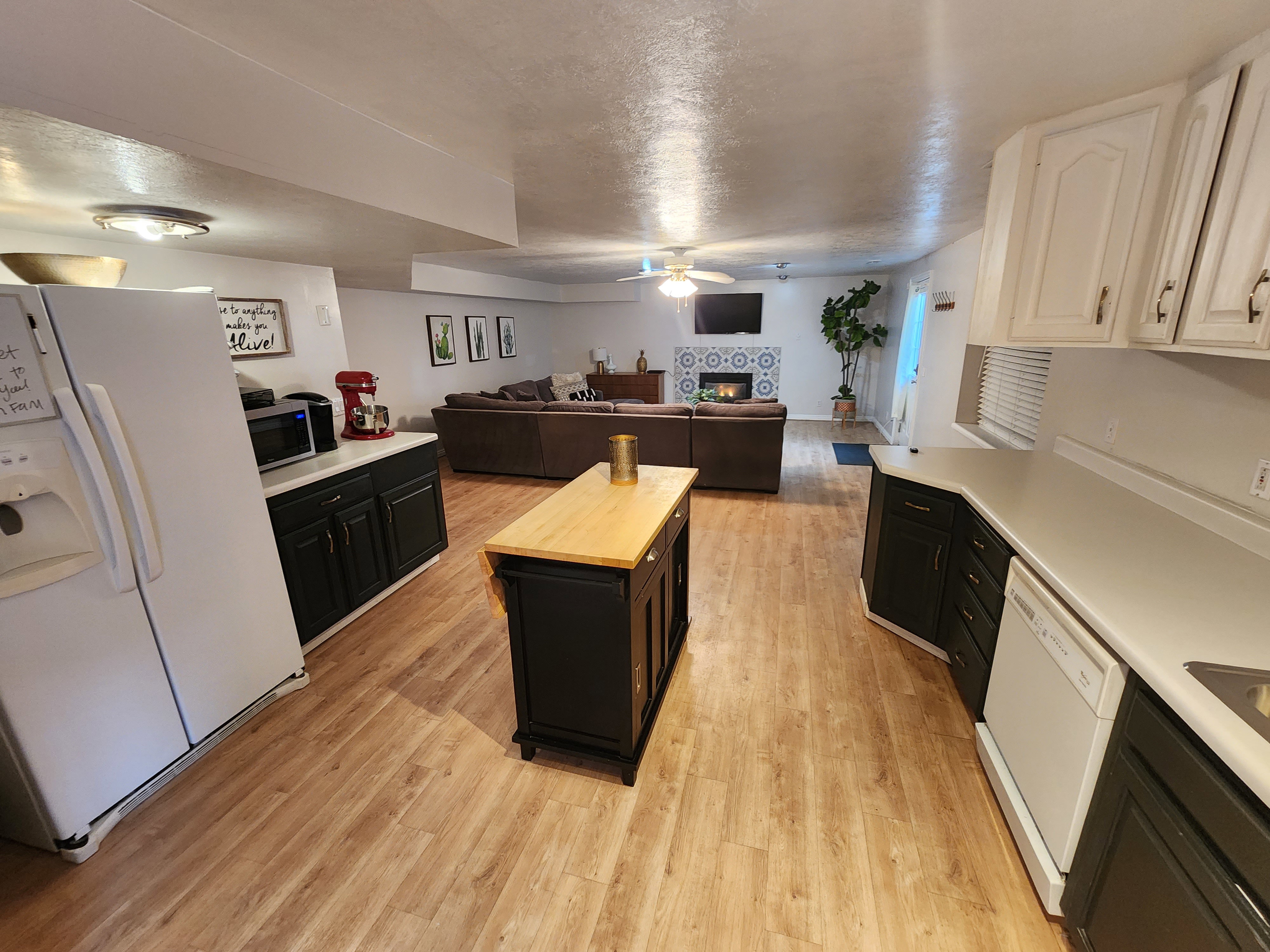Spacious kitchen featuring wood-finish flooring, dark cabinetry, and light countertops