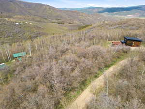 Mountainous terrain featuring two residential structures and a winding dirt road
