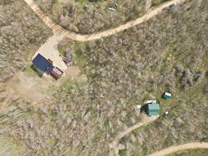 Aerial view of expansive tree-covered grounds with two distinct structures and multiple unpaved access paths