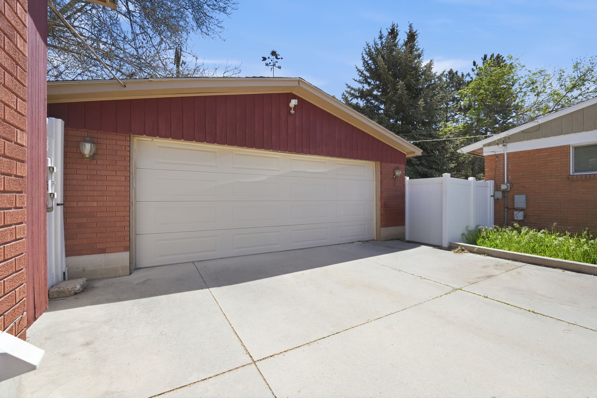 Concrete driveway leading to a two-car garage with white panel door