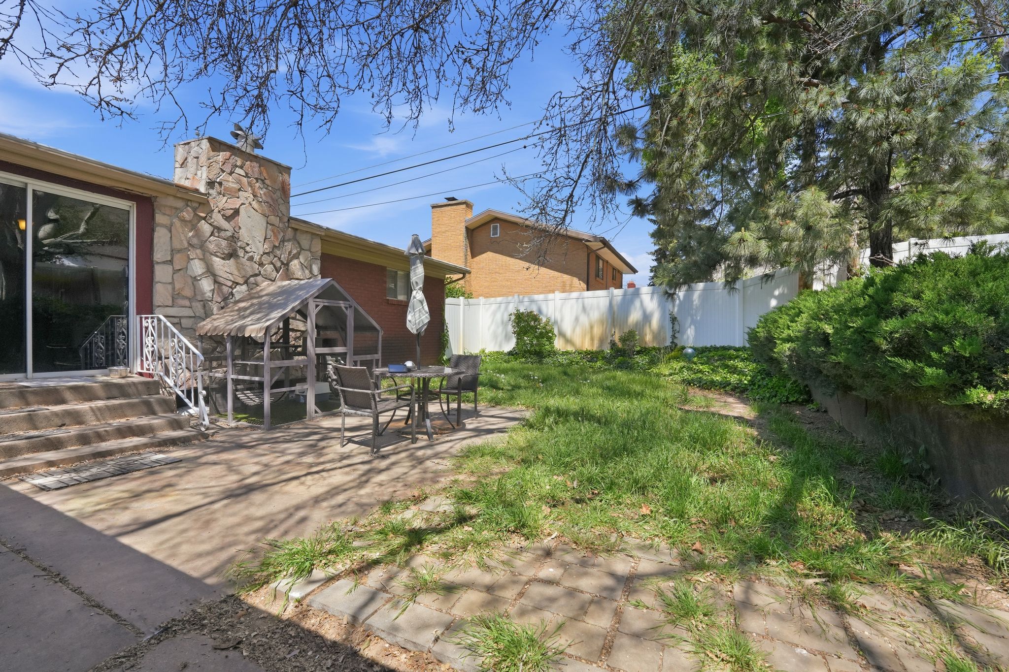 Rear patio with stone facade and a large sliding glass door