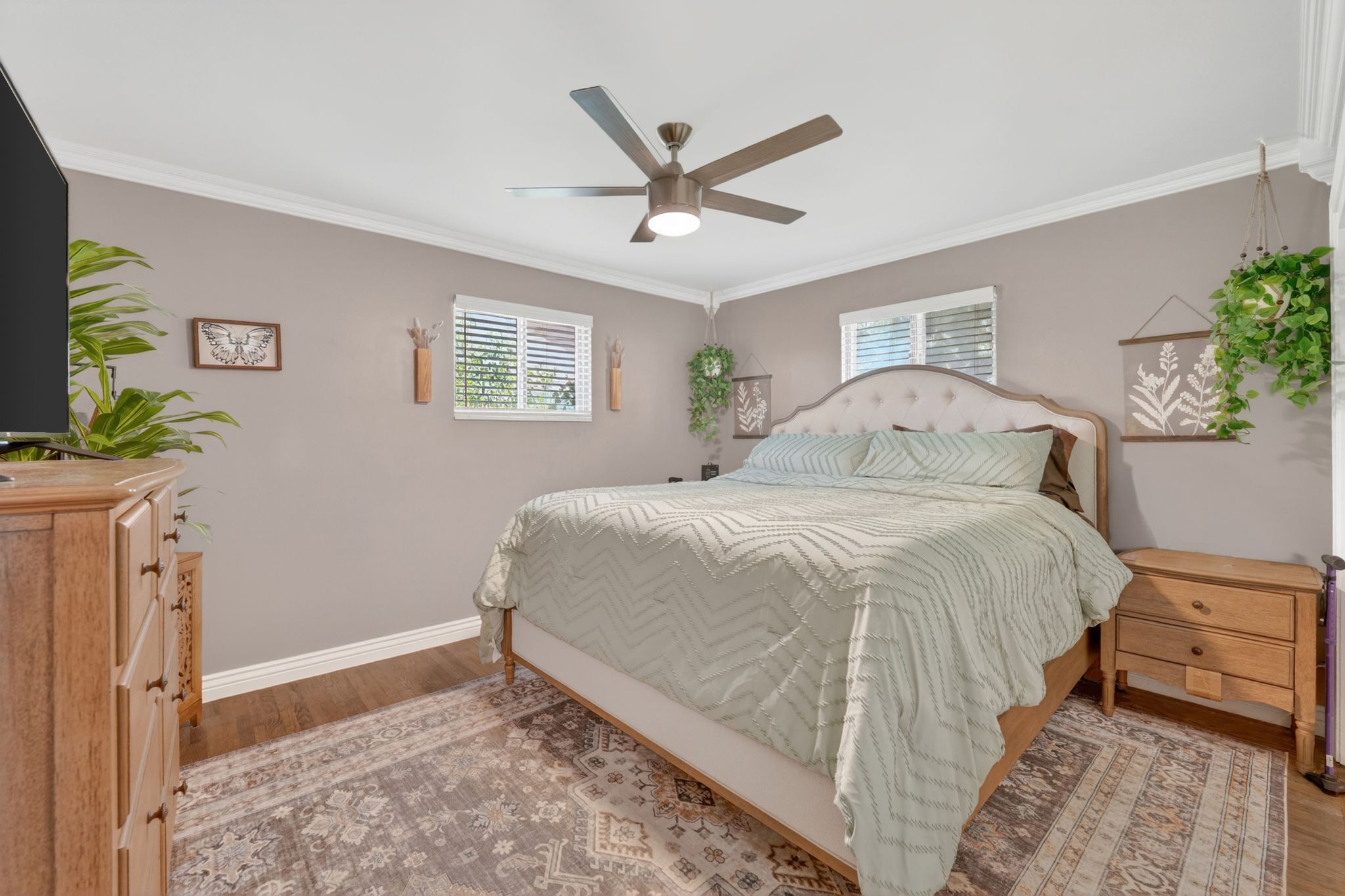 Spacious room featuring wood-finish flooring and crown molding