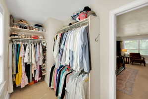 Walk-in closet featuring extensive built-in shelving and multiple hanging rods