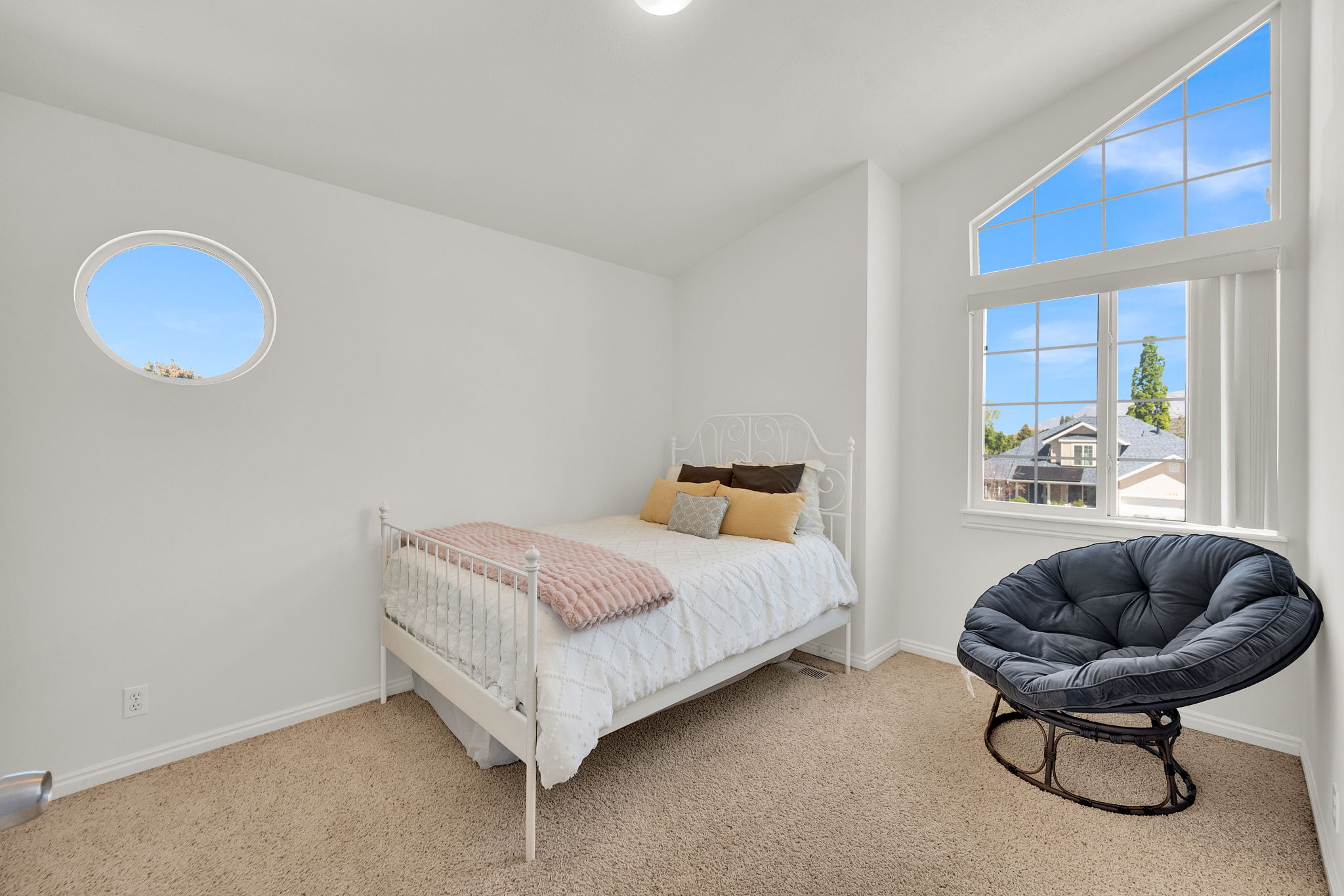 Bright room featuring a large, multi-pane window and a distinctive circular window