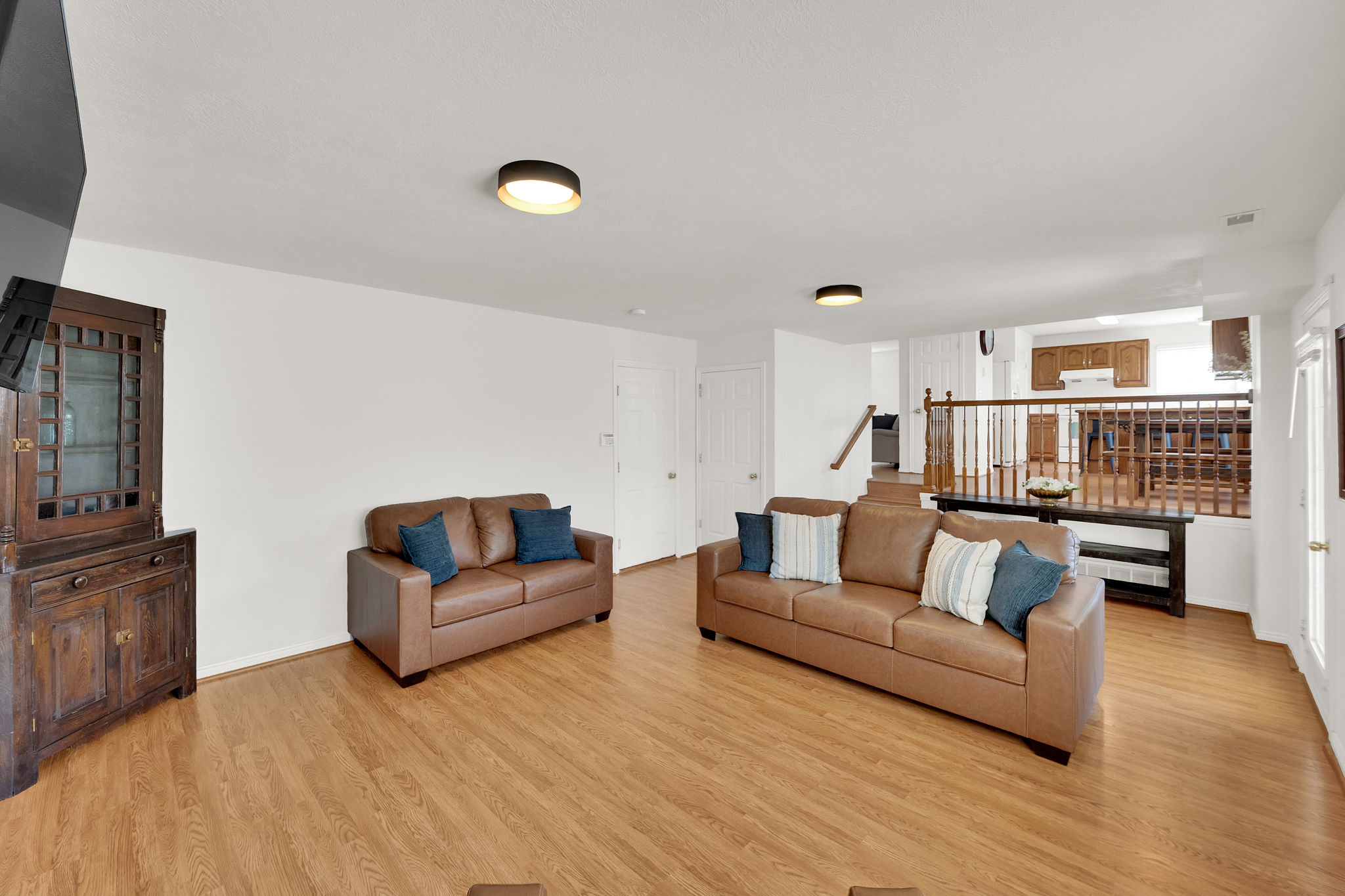 Spacious living area featuring wood-finish flooring, recessed lighting, and a neutral color palette