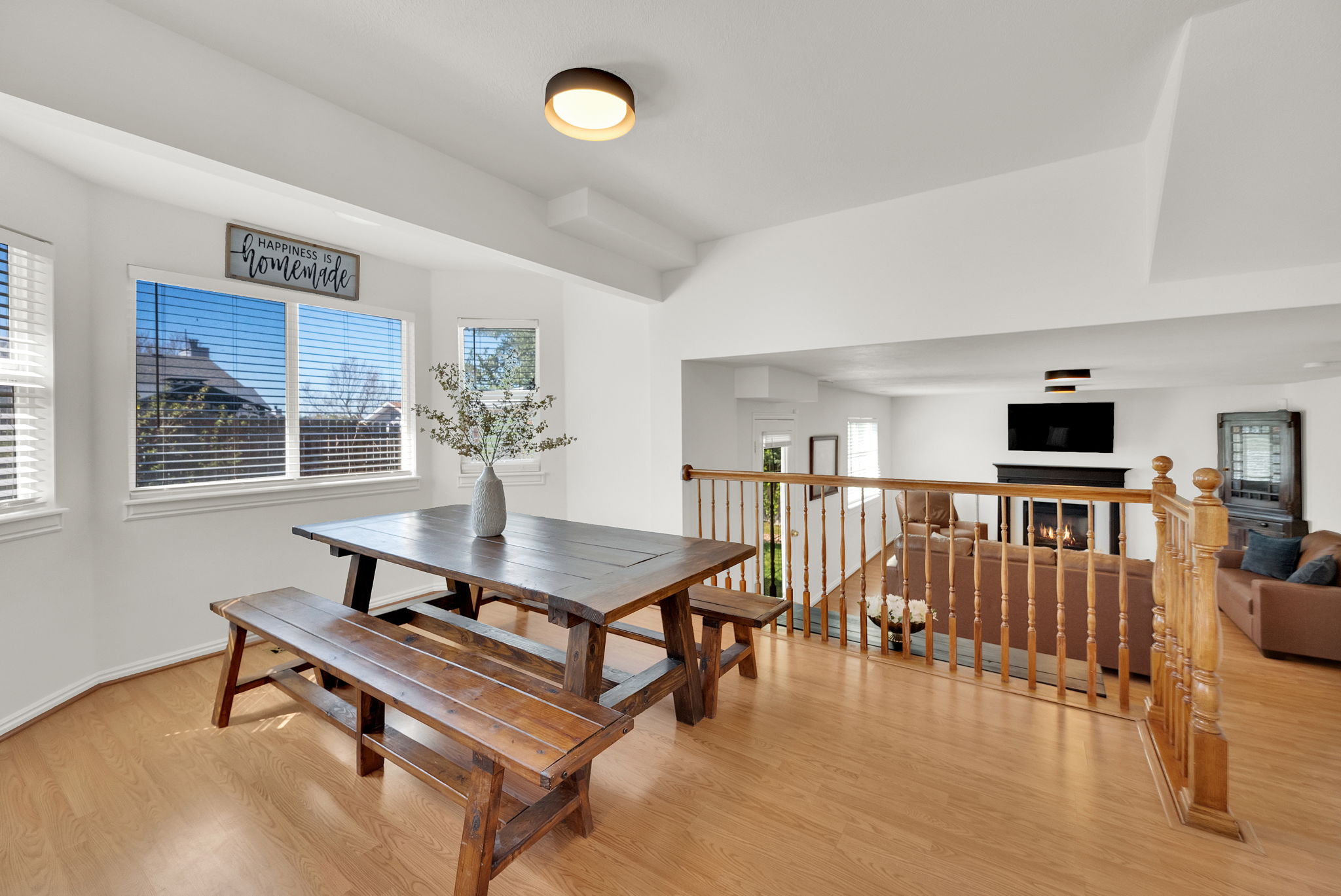 Dining area with wood-finish flooring and ample natural light from multiple windows
