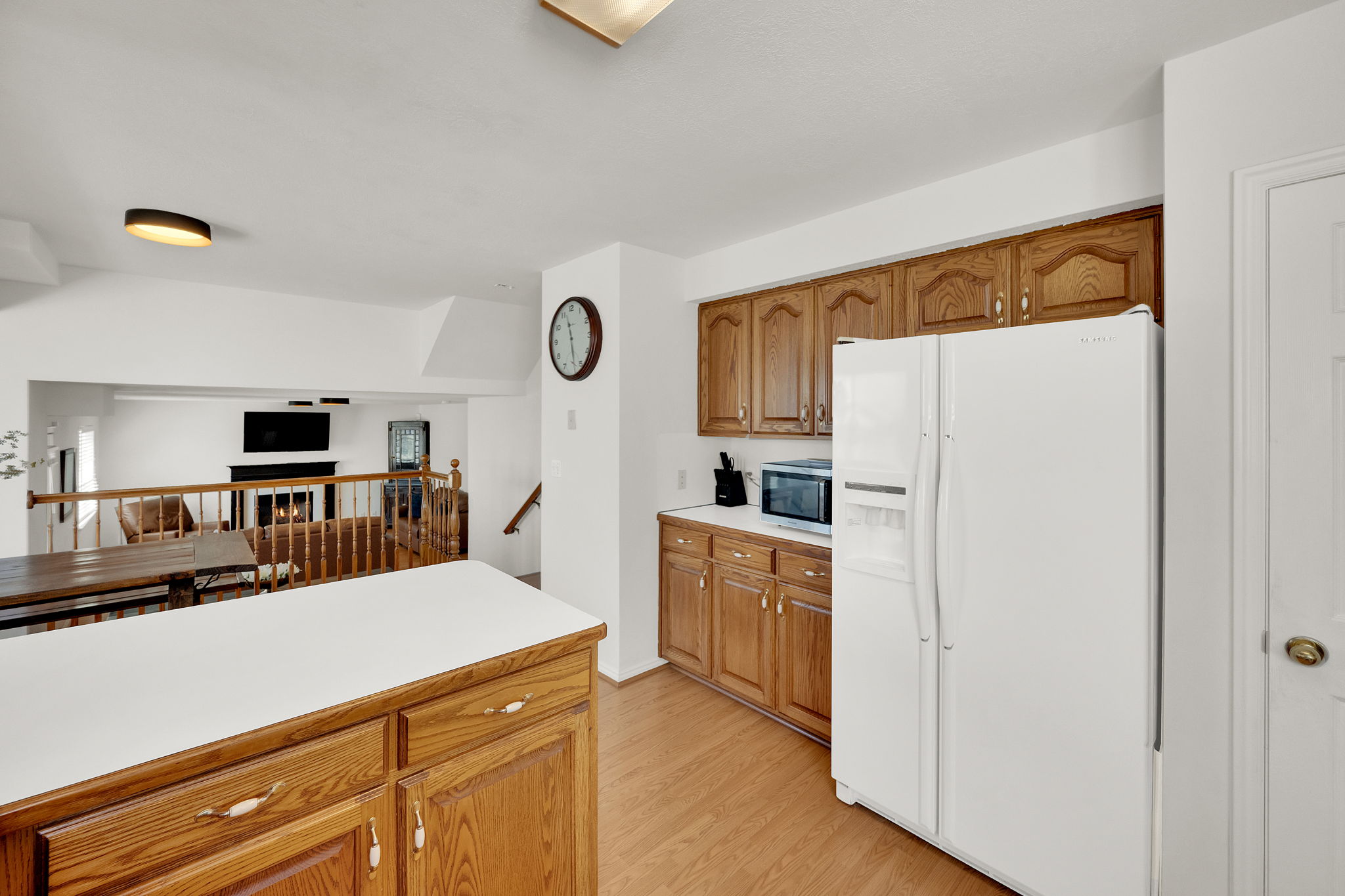 Kitchen featuring wood-finish cabinetry, white countertops, and wood-finish flooring