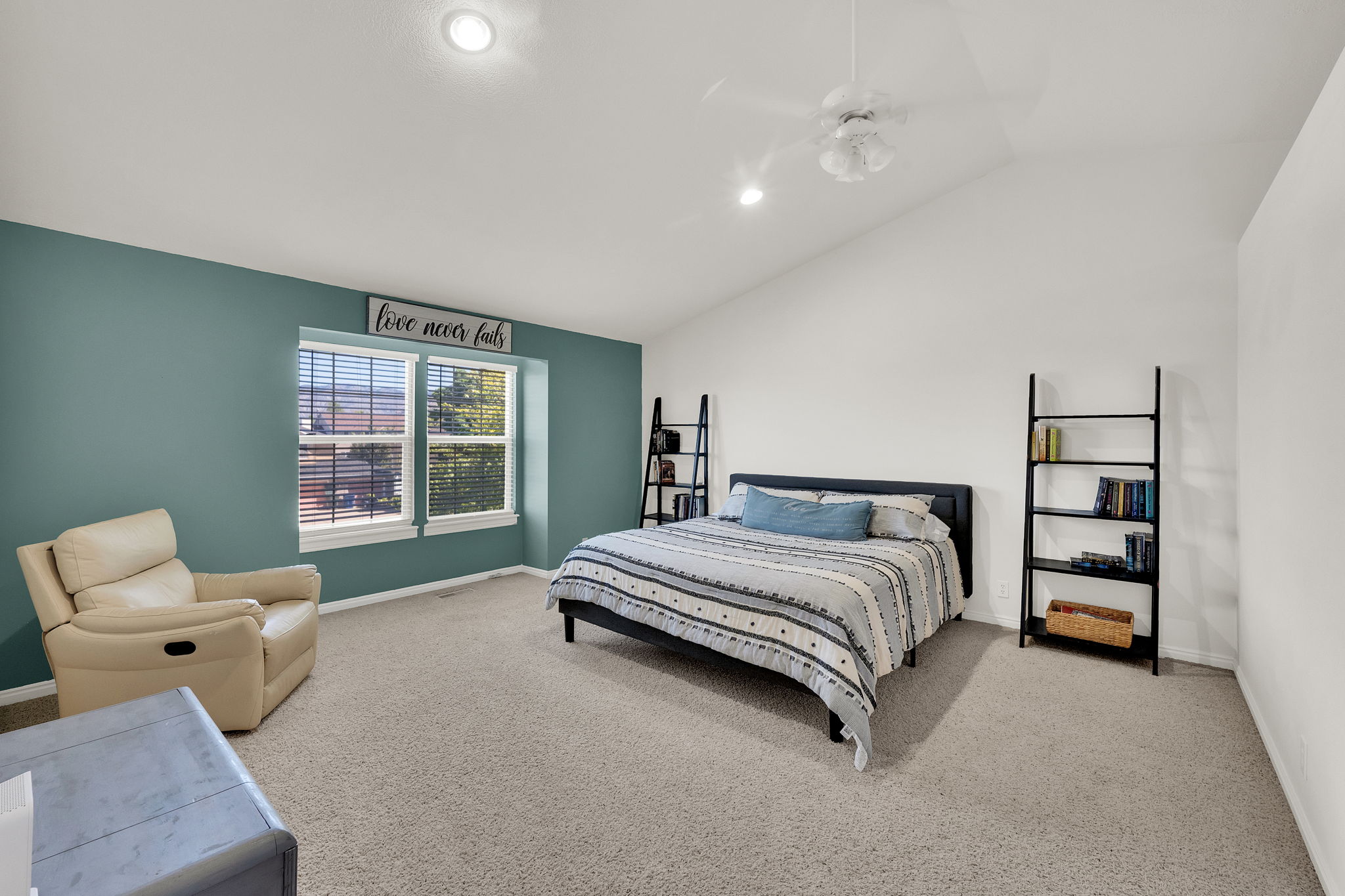 Spacious room featuring a vaulted ceiling with a ceiling fan, recessed lighting, and soft carpet flooring