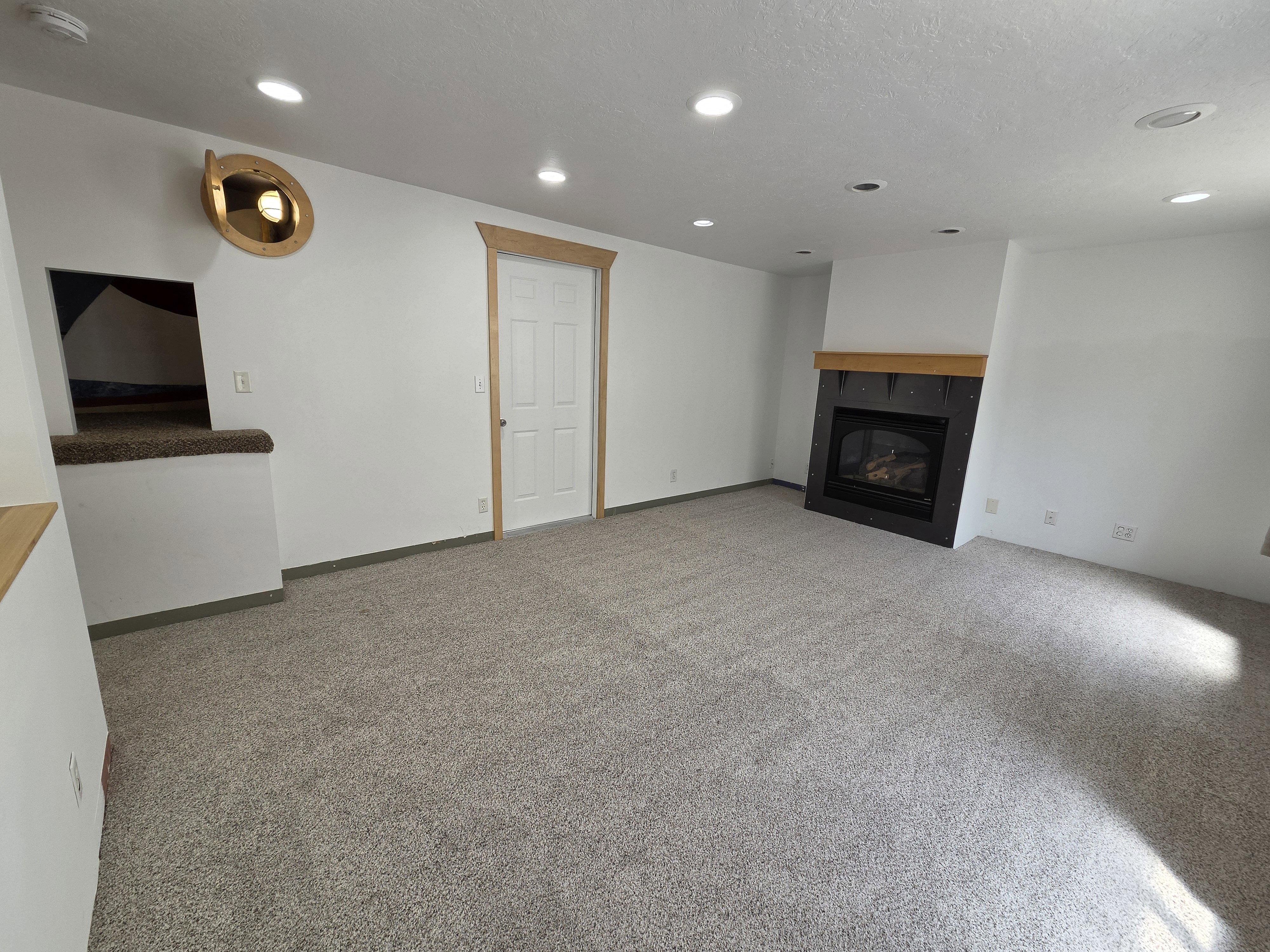 Spacious room with a gas fireplace featuring a wood mantel