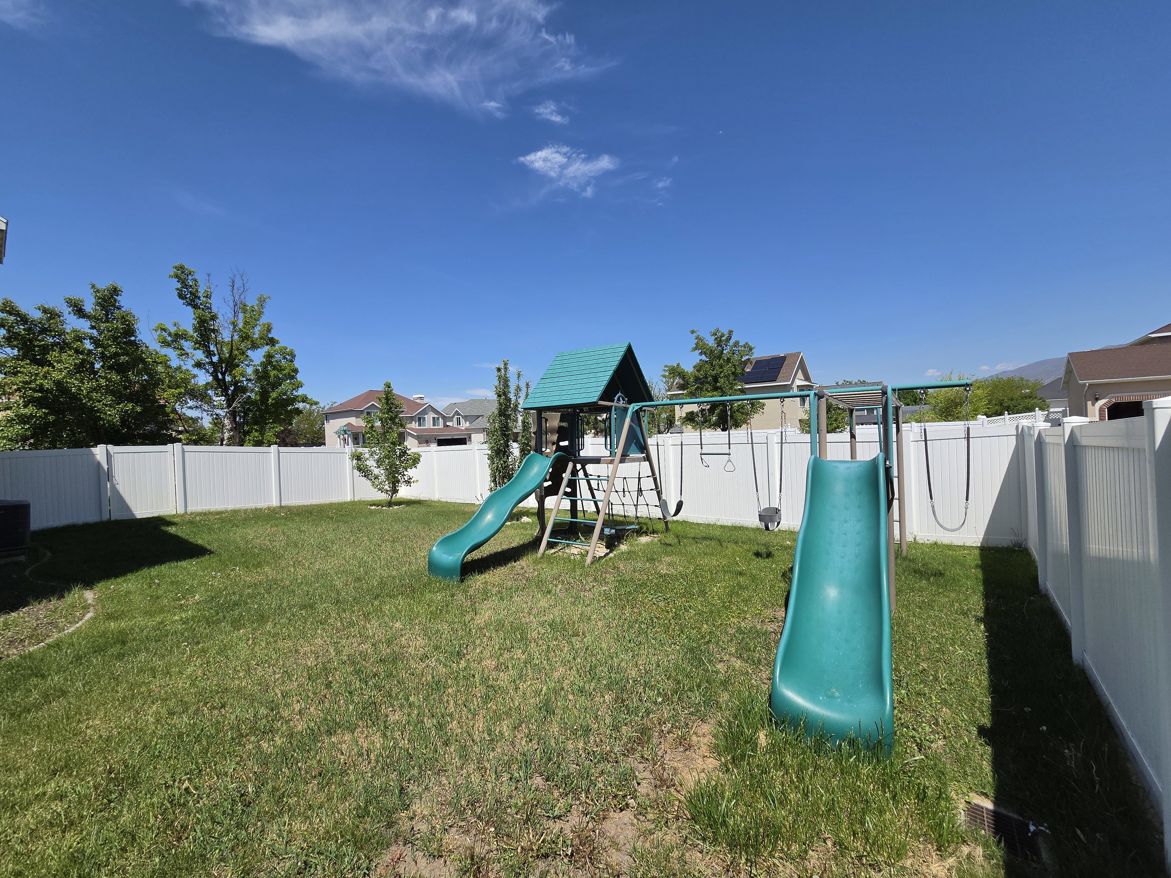 Expansive backyard with a manicured lawn, complete with a vinyl privacy fence