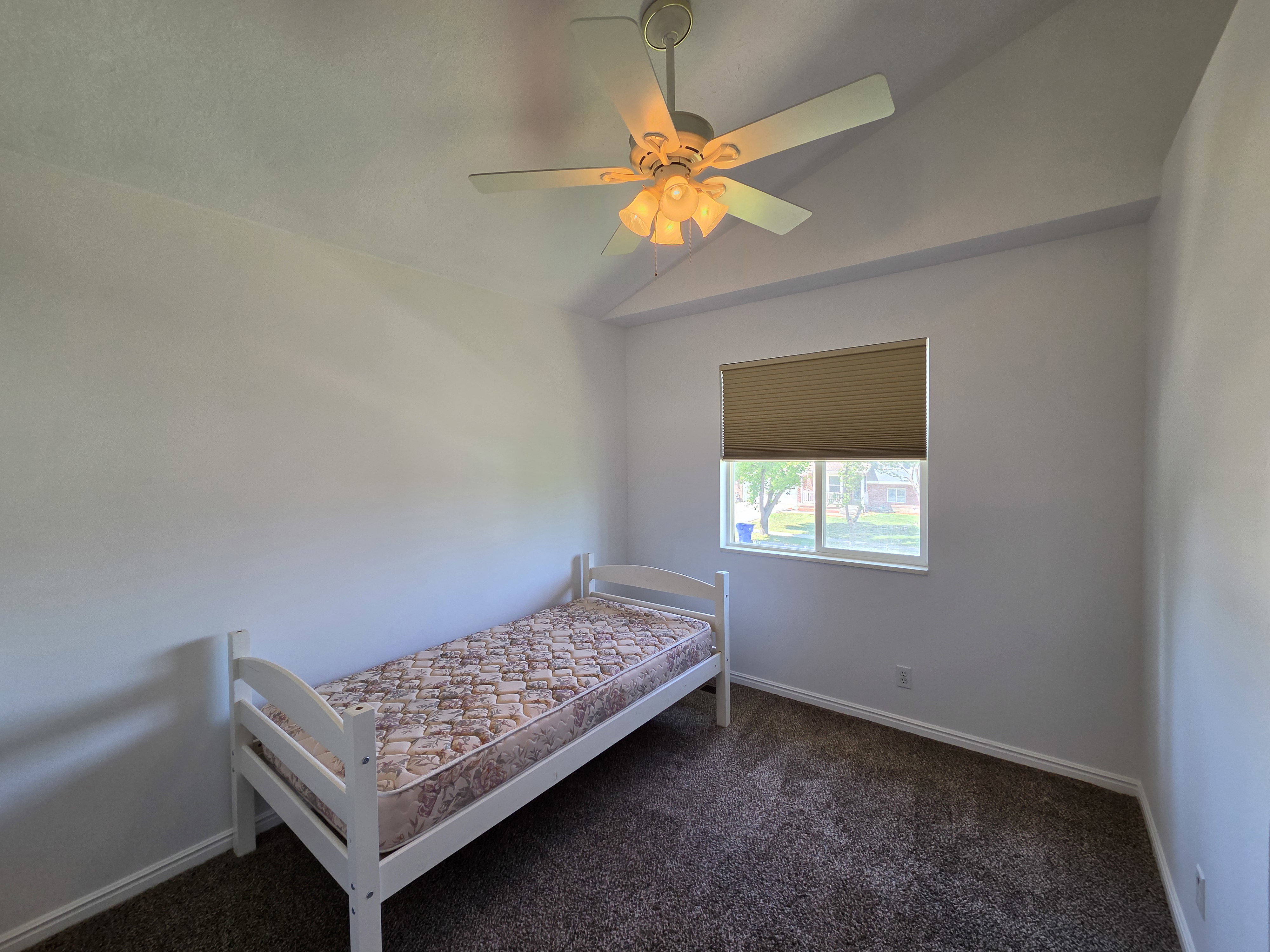 Room featuring vaulted ceilings and a ceiling fan with integrated lighting