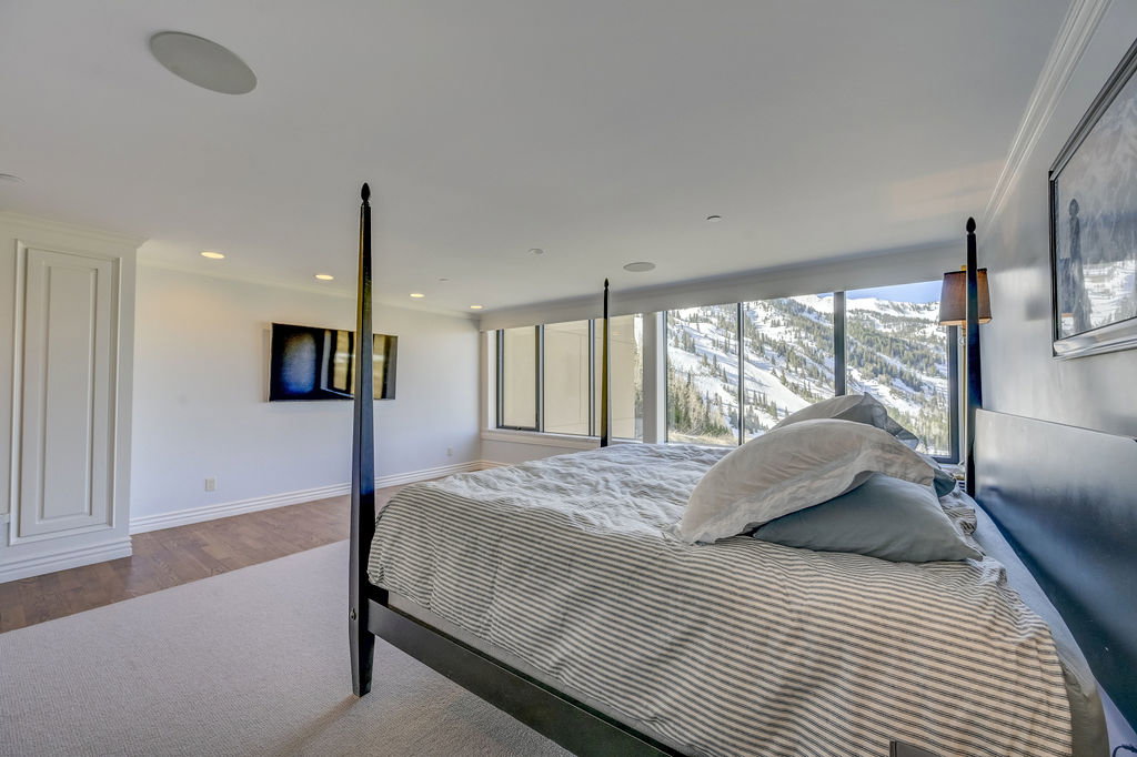 Floor-to-ceiling windows with mountain scenery, recessed lighting, built-in ceiling speakers, crown molding, and two-tone wall finishes