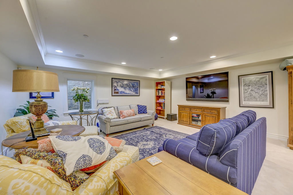 Spacious lower-level living area with recessed lighting, crown molding, and light wood-finish flooring