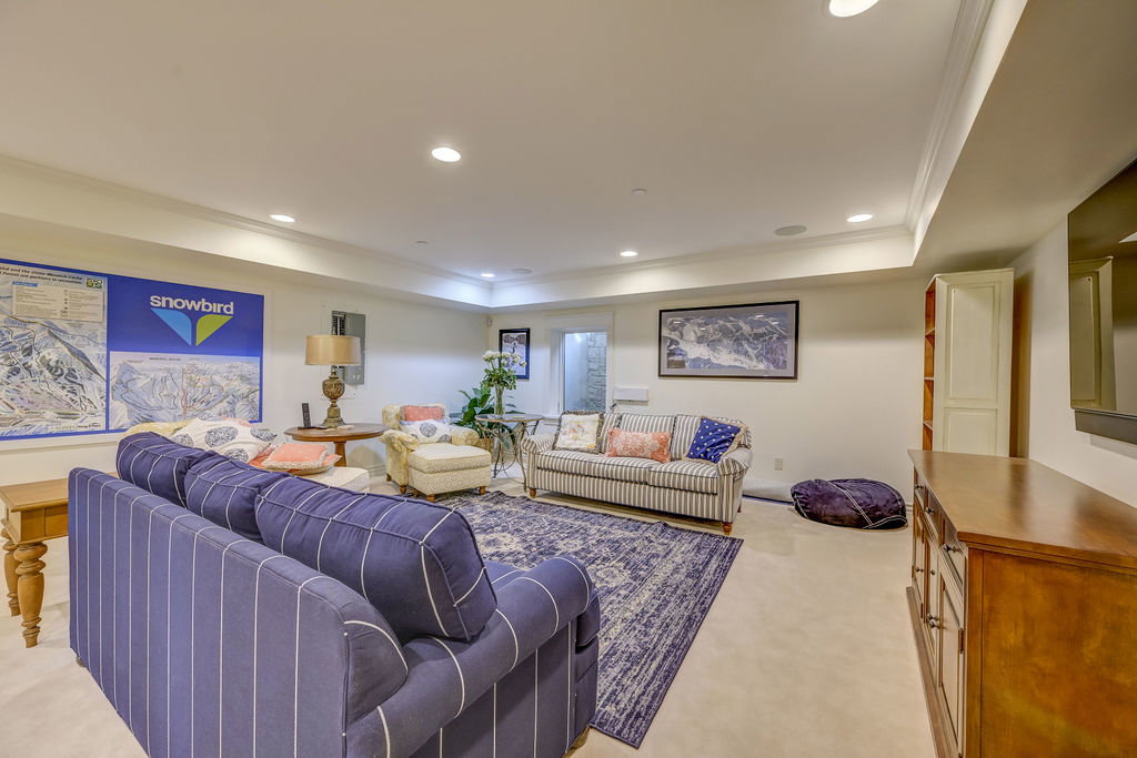 Spacious living area featuring neutral walls, recessed lighting, crown molding, and light-colored flooring