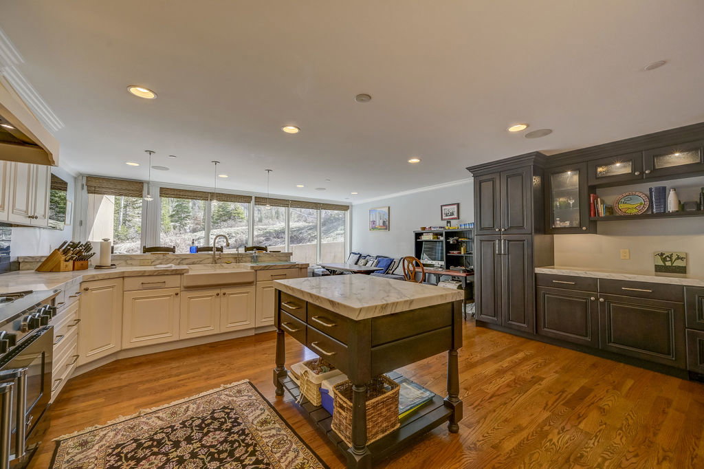 Gourmet kitchen with wood-finish flooring and a central island featuring a light-toned countertop
