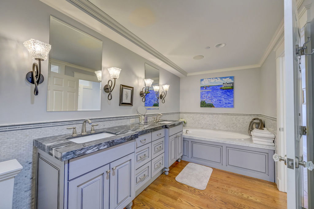 Dual vanity with custom cabinetry and undermount sinks, complemented by a built-in soaking tub