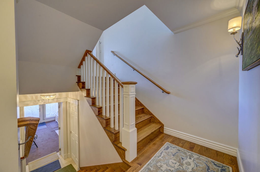 Hardwood staircase with white balusters and a wood handrail