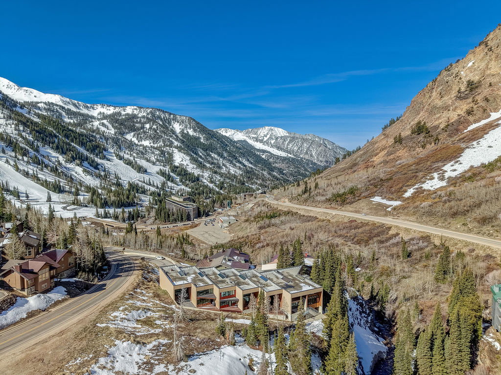 Contemporary architecture situated in a mountainous environment featuring rugged terrain and evergreen trees