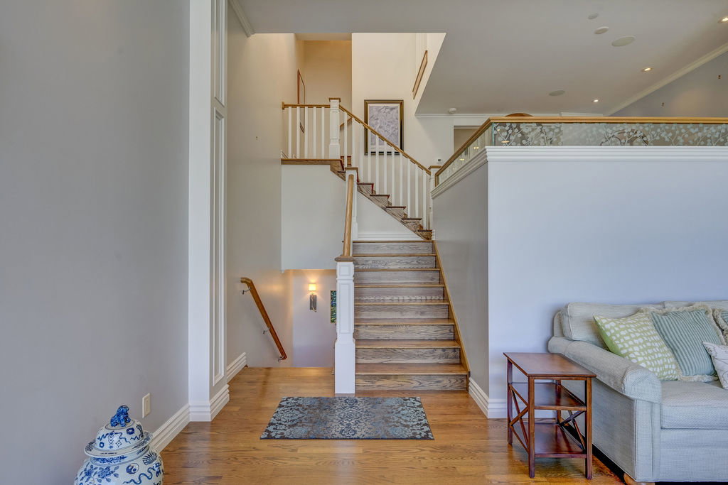 Hardwood staircase with white balusters and natural wood handrails