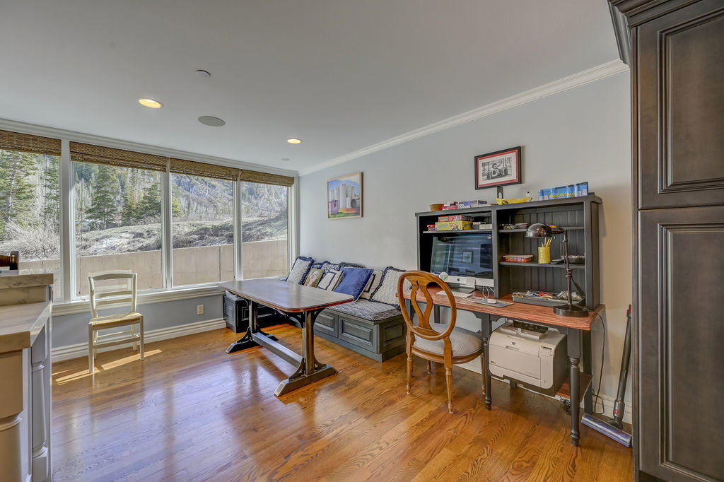 Expansive windows with natural light, wood-finish flooring, recessed lighting, crown molding, and a built-in bench seating area
