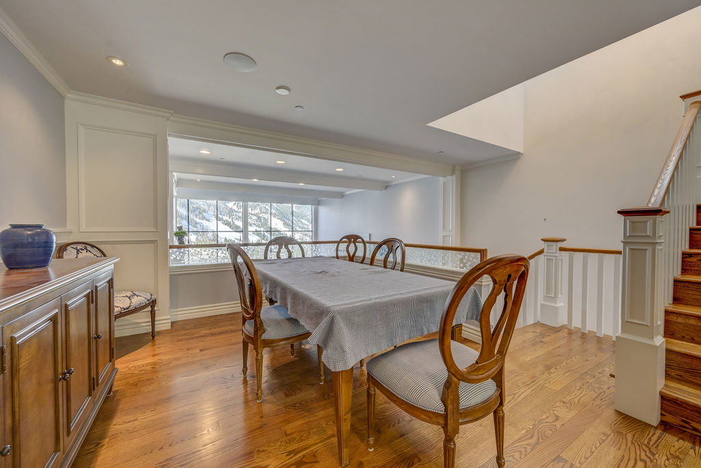 Hardwood flooring throughout featuring recessed lighting, a built-in buffet, and a wood-railed staircase