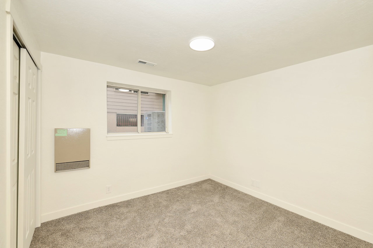 Interior space featuring light gray carpet, white walls, and a white ceiling with flush-mount lighting