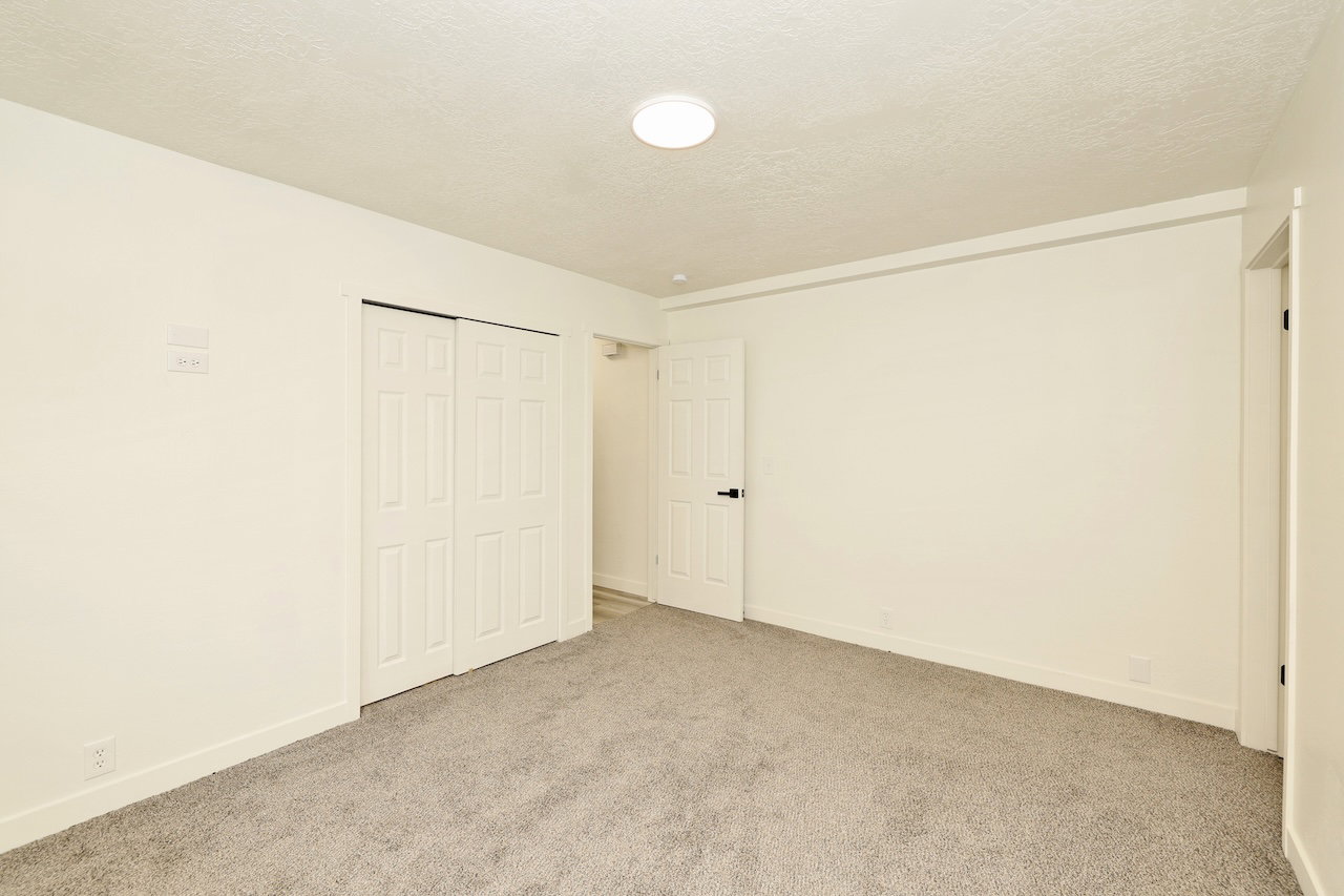 Room featuring neutral-toned walls, grey carpet flooring, and a flush-mount ceiling light fixture
