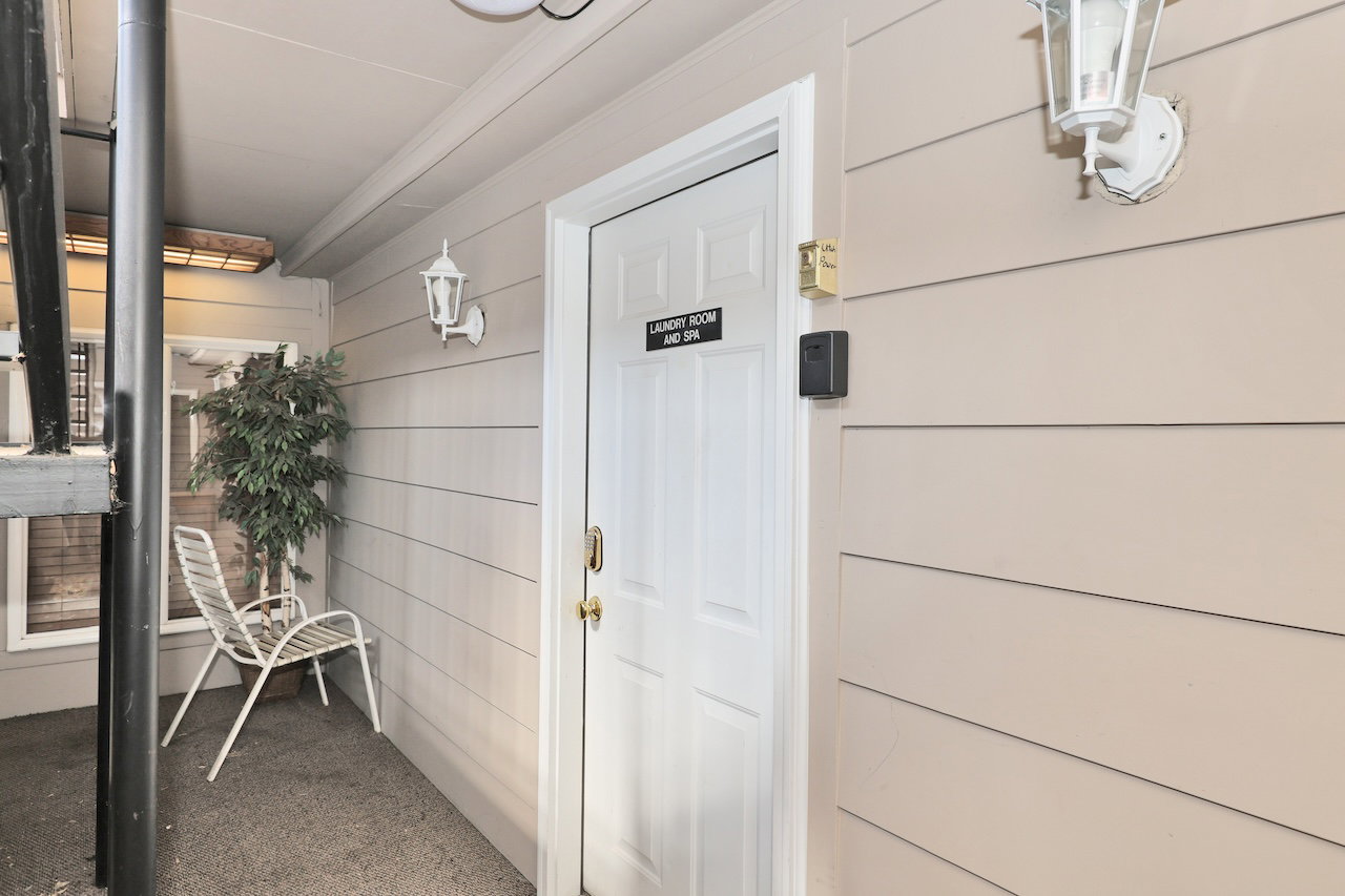Entryway with horizontal siding and a paneled door featuring a brass handle