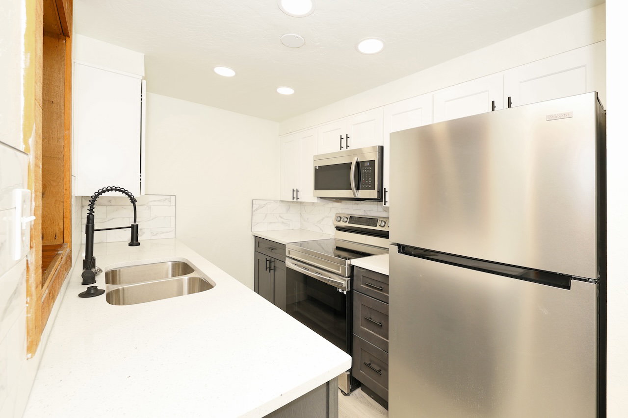 Modern kitchen featuring white shaker upper cabinetry and contrasting gray lower cabinetry