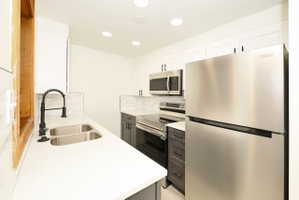 Modern kitchen featuring white shaker upper cabinetry and contrasting gray lower cabinetry