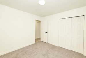 Neutral-toned room with light gray carpet flooring and white baseboards
