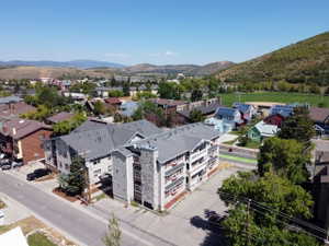 Multi-story building featuring stone and siding exterior, balconies, and dormer windows