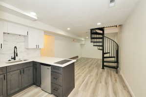 Open-concept living space with a contemporary kitchen area and spiral staircase