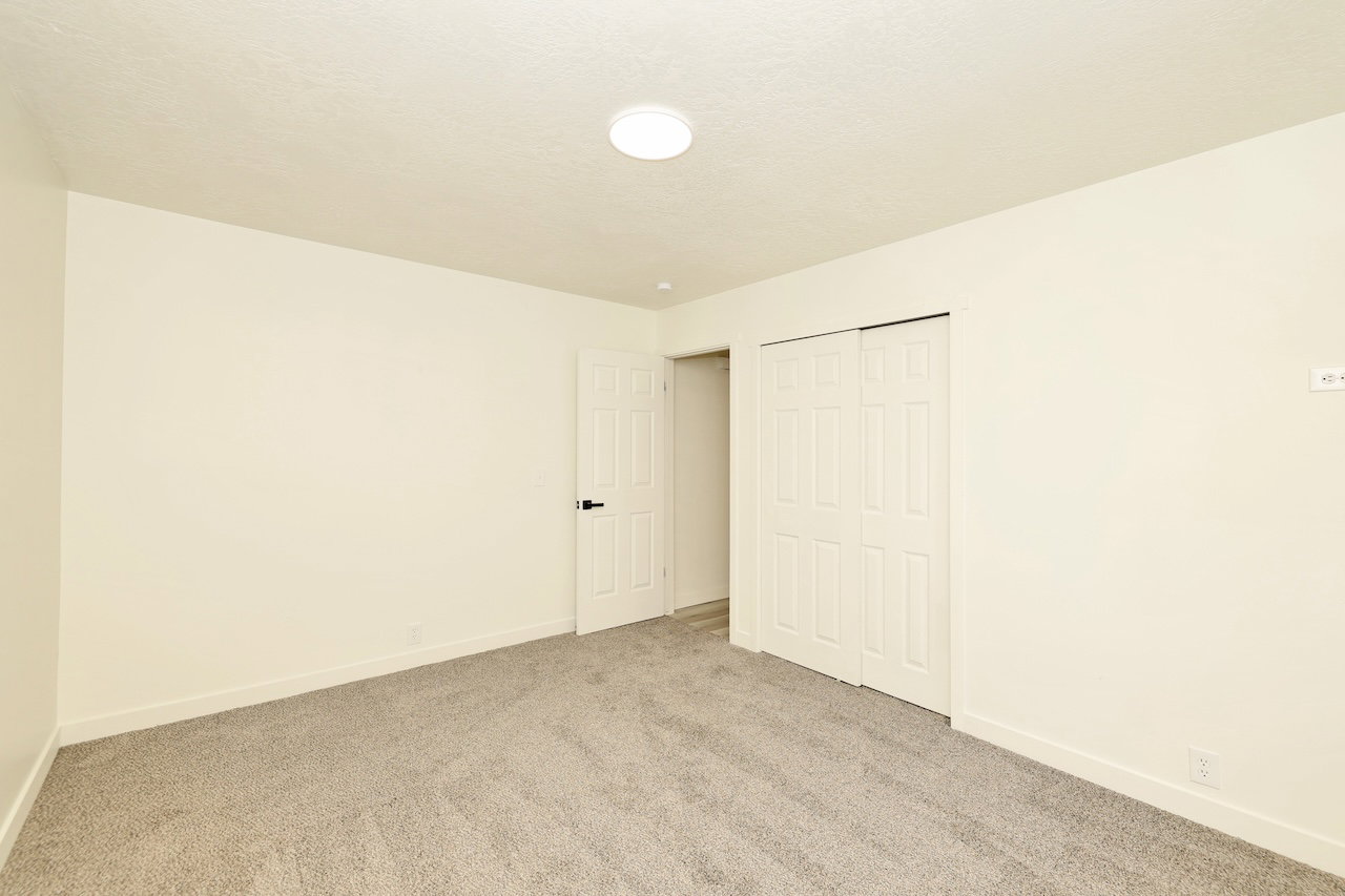 Room featuring light cream walls and plush gray carpeting