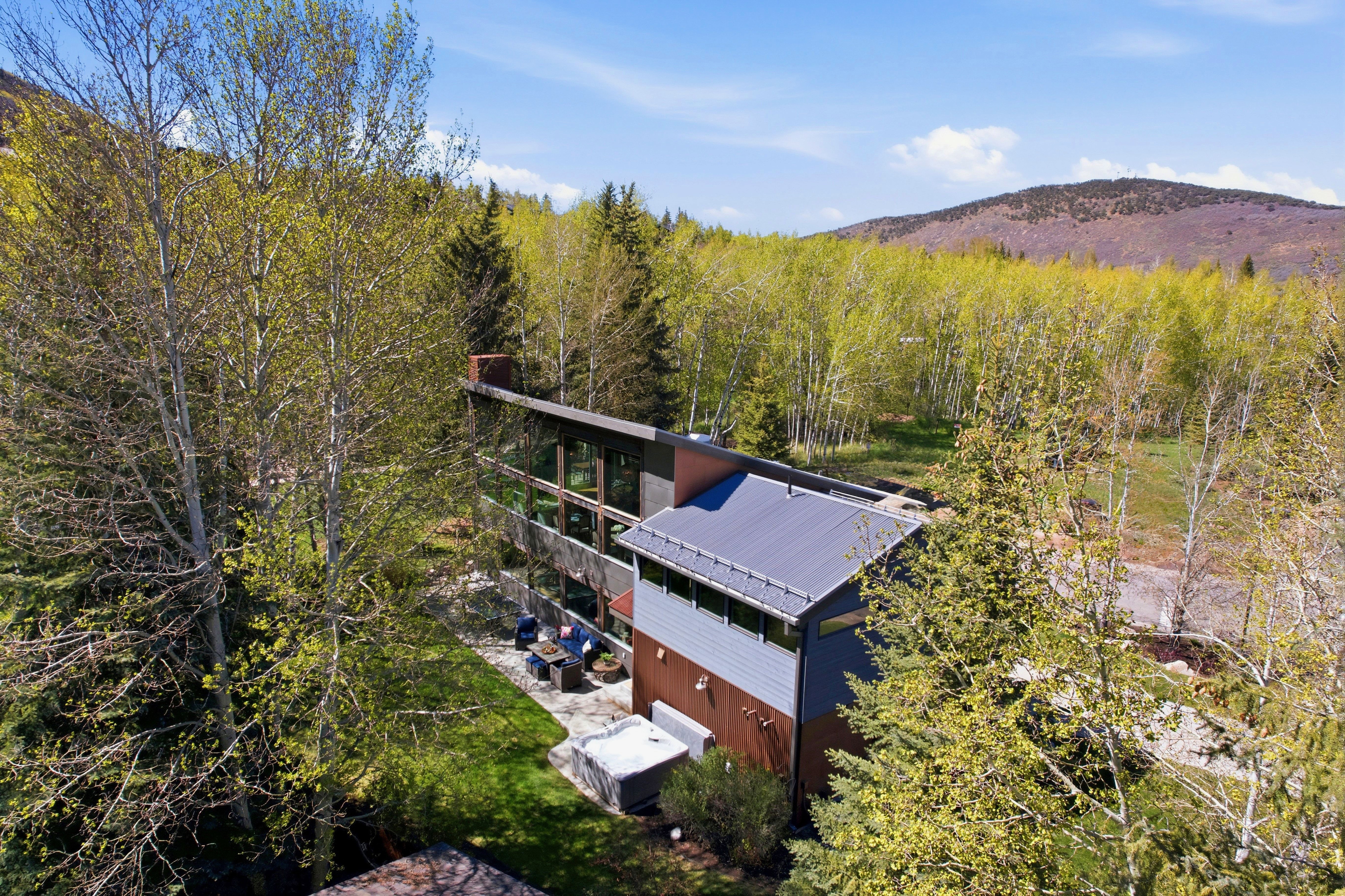 Contemporary architecture featuring a multi-level design, extensive glazing, and a metal roof