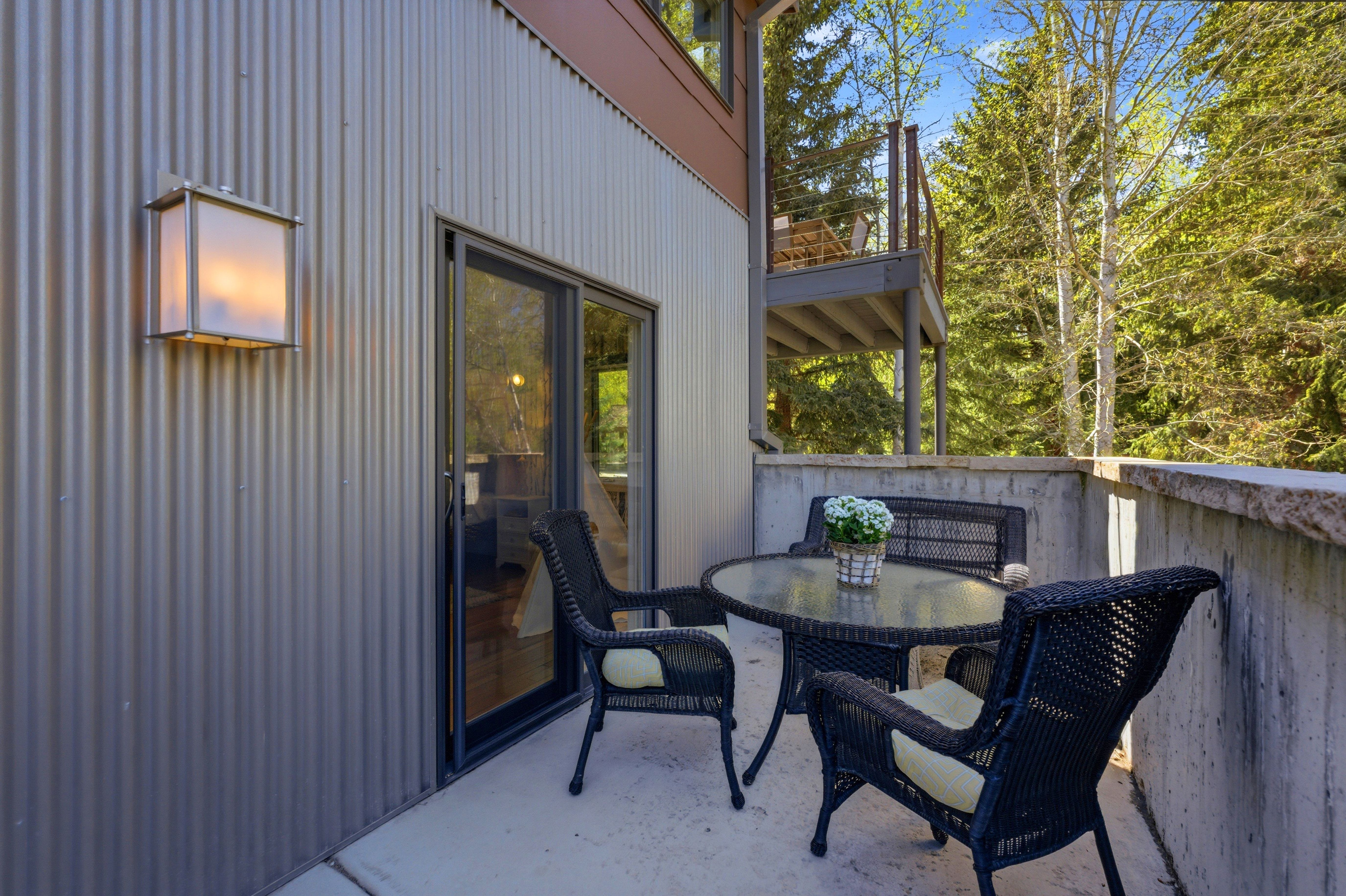 Private exterior patio featuring concrete flooring and a concrete retaining wall