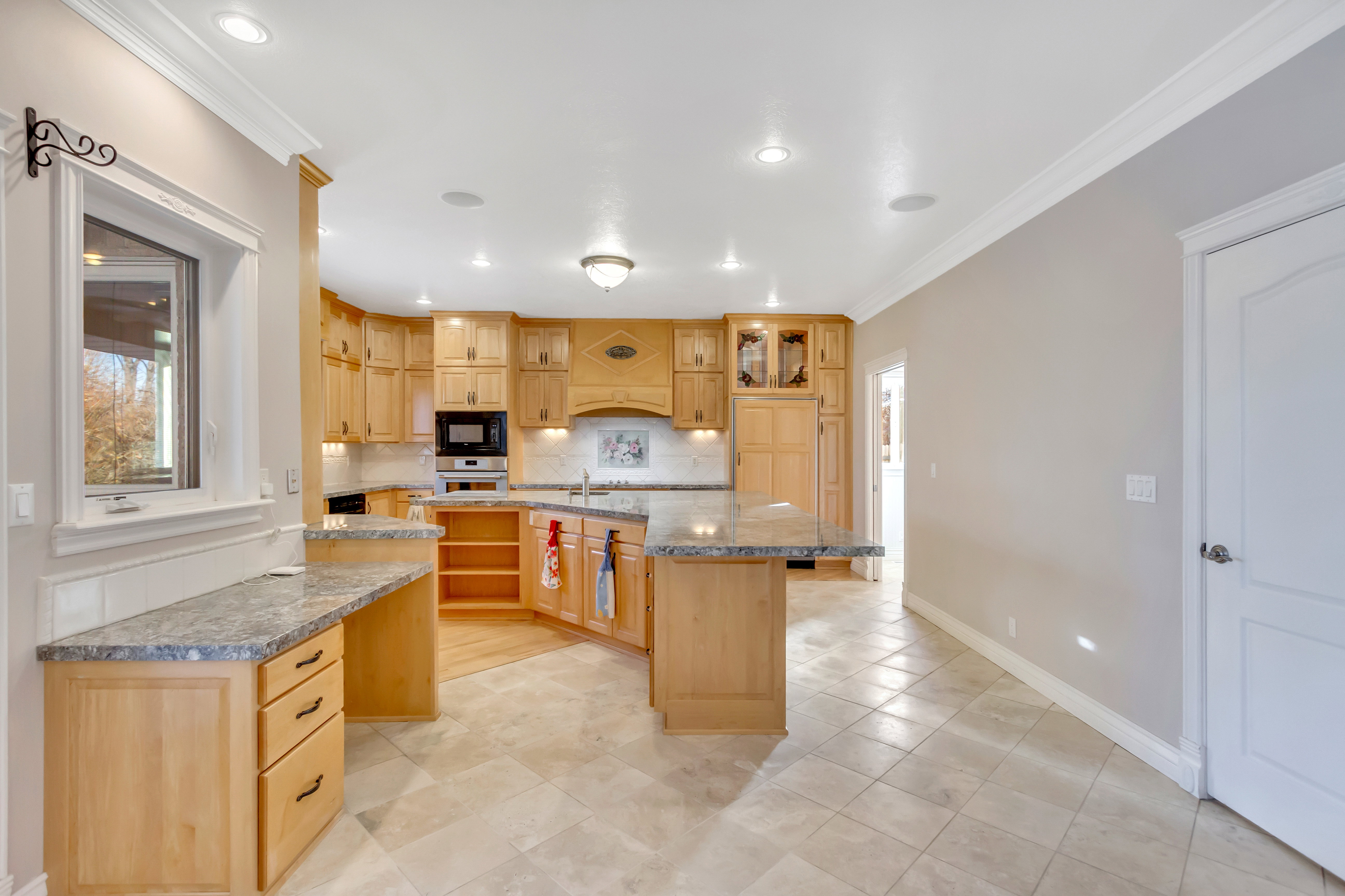 Kitchen featuring light wood cabinetry, stone countertops, and recessed lighting