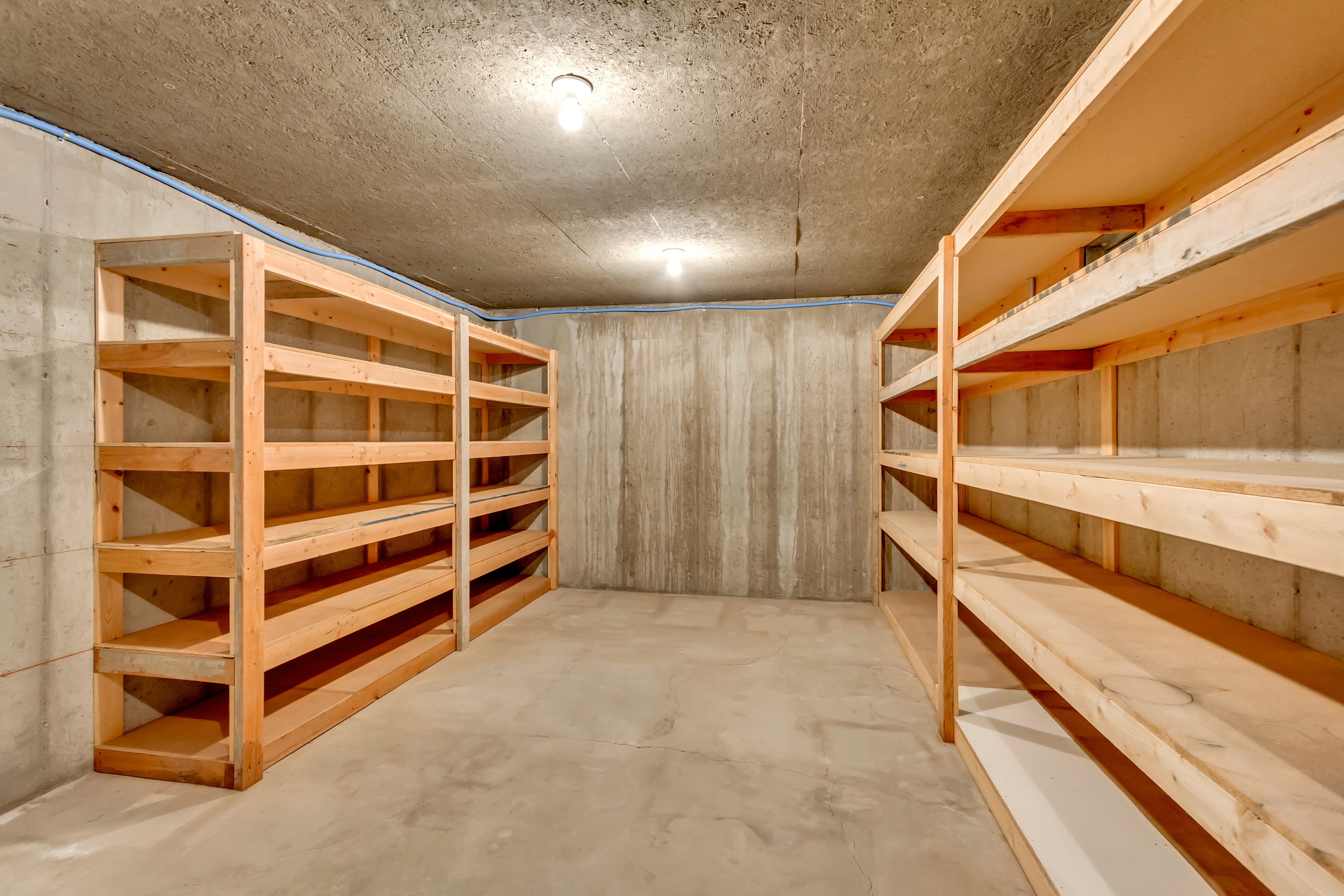 Storage area featuring concrete walls, concrete flooring, and exposed ceiling