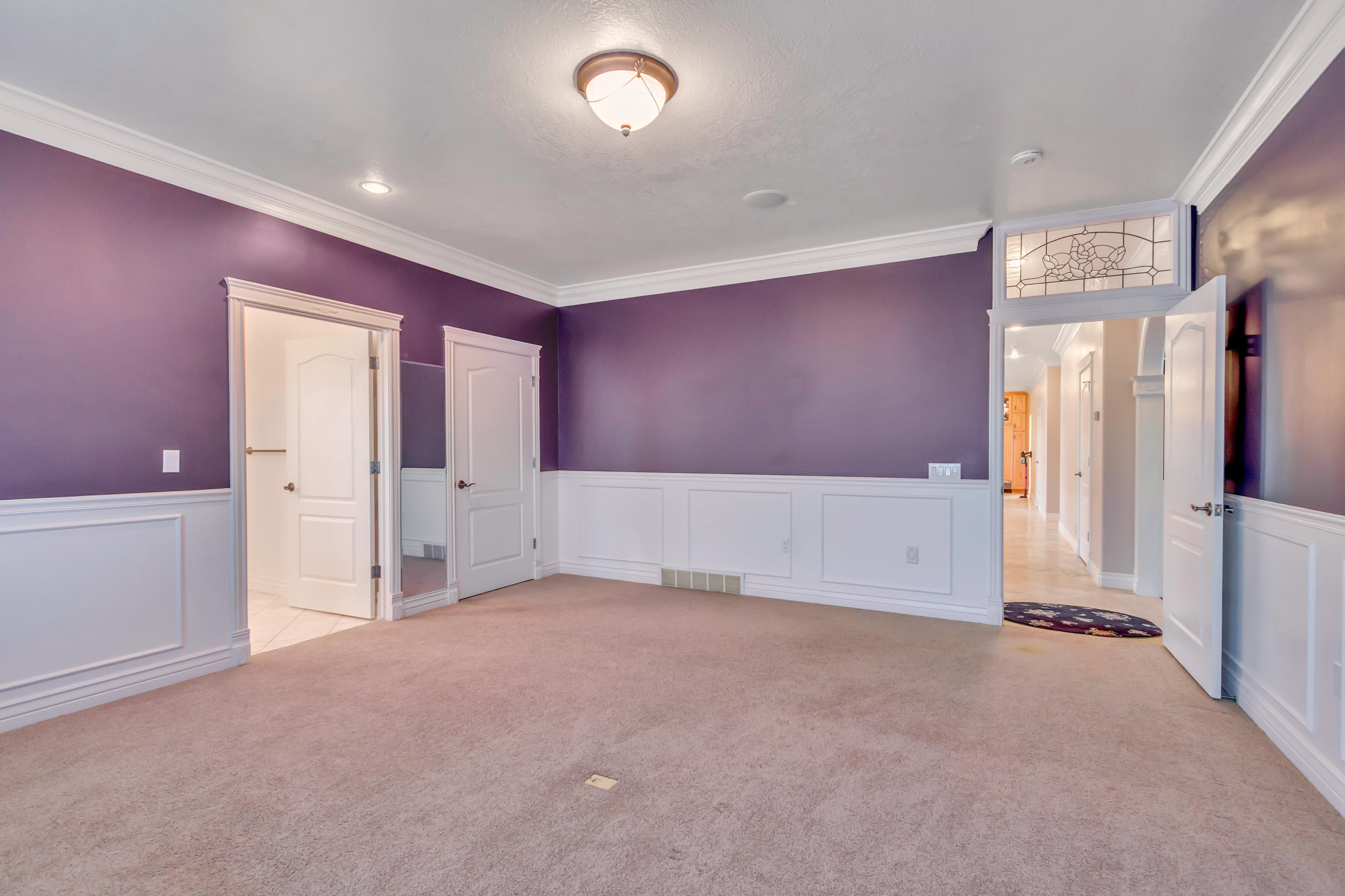 Carpeted interior space featuring wainscoting, crown molding, and two panel doors