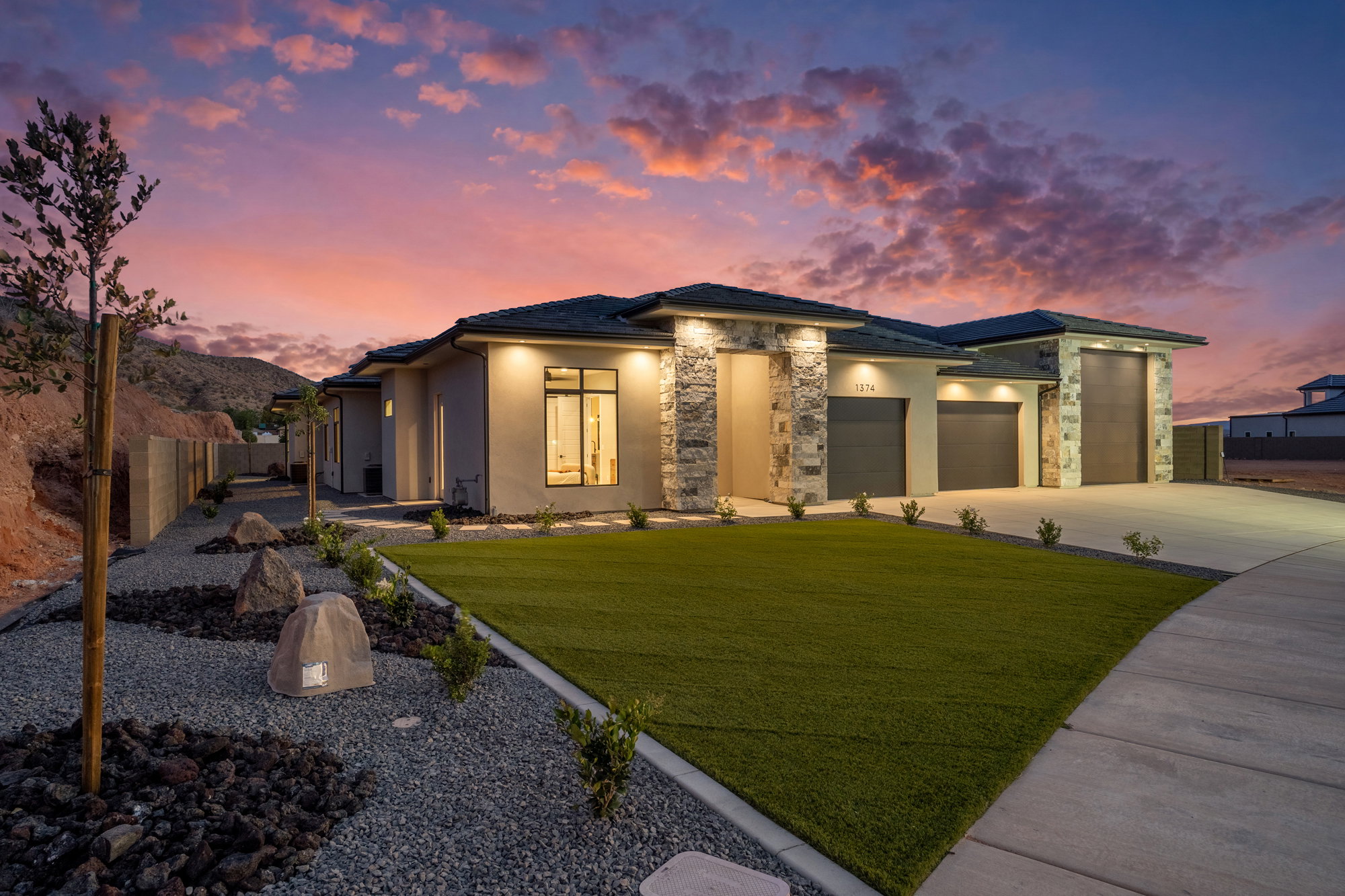 Modern stucco exterior with stone accents and a multi-car garage