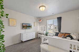 Carpeted spare bedroom featuring light neutral paint and large window