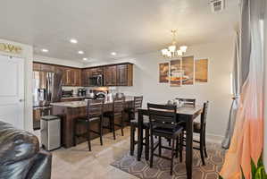 Spacious open concept kitchen featuring dark wood cabinetry, granite countertops, stainless steel appliances, and a walk-in pantry