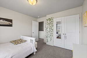 Carpeted spare bedroom featuring light neutral paint and large window