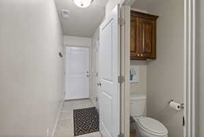 Entryway featuring tile flooring and two-tone paint, with half bathroom nearby