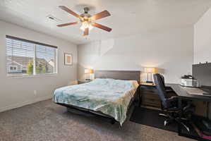Spacious primary bedroom featuring carpet flooring, light neutral paint, large window and ceiling fan