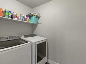 Dedicated laundry area featuring a built-in wall shelf and two appliance hookups