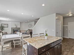 Kitchen island featuring a granite countertop and dark wood-finish cabinetry