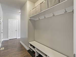 Entryway featuring wood-finish flooring and a built-in storage bench with shoe cubbies