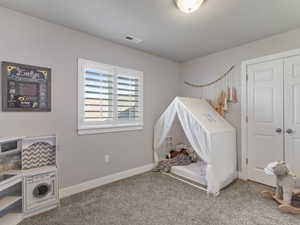 Carpeted room featuring a double-pane window with white plantation shutters, white baseboards, and a semi-flush mount ceiling light